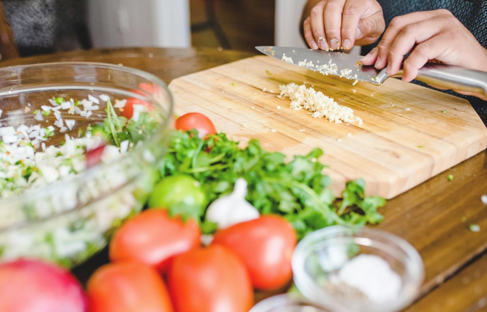 Students practicing knife skills in professional cooking class environment